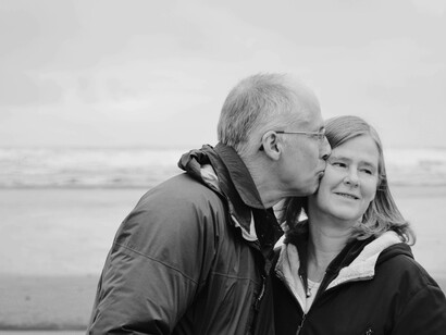 A man and a woman in their latter aging years are on the beach and enjoying the romantic setting
