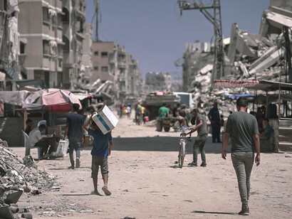 In 2024, Gaza is marked by widespread destruction, with bombed buildings reduced to rubble and people trying to survive amid the ruins