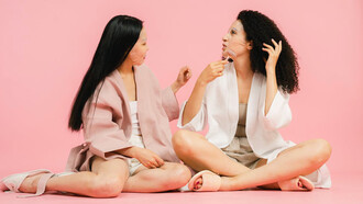 Two women applying a natural face mask, embracing time-honored South Asian self-care rituals often overlooked by the West