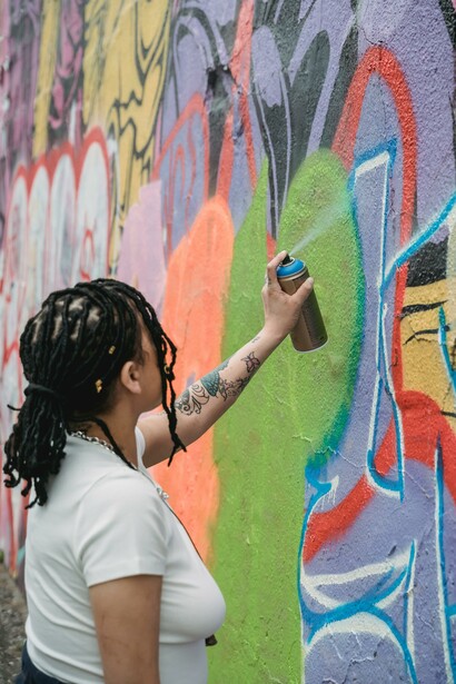 Woman making graffiti art on a wall