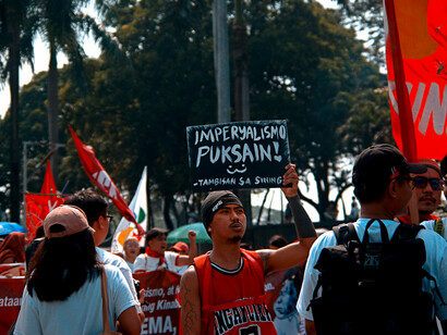 Protesters in the Philippines holding colorful banners during an outdoor demonstration