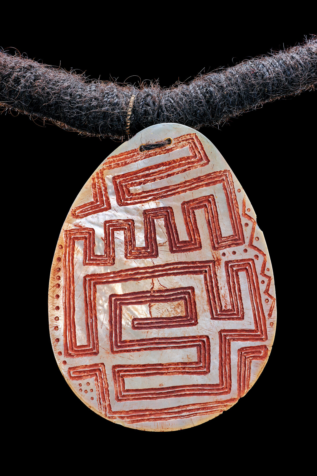 Nacre gravée riji, Australie-Occidentale, Kimberley, baie Beagle, péninsule de Dampier 
Nyulnyul. Fin du 19e siècle, premier quart du 20e siècle, Nacre, cheveux, fibres végétales, ocre, L 64 cm l 13,2 cm, Acquis d’Emile Clement en 1928. Photo: © MEG, J. Watts