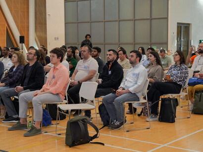 A diverse group of participants attending an indoor conference on civil society, engaging in discussions on community development and participation