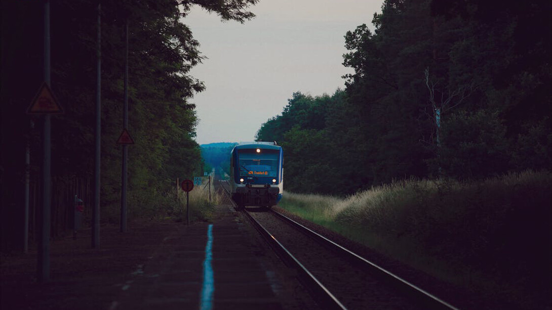Amidst the train station's buzz, lone travellers wait unseen, challenging stereotypes and embracing the thrill of discovery