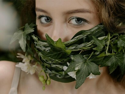 A close-up of a woman above a floral piece covering her mouth, symbolising the emotional confinement created by social anxiety