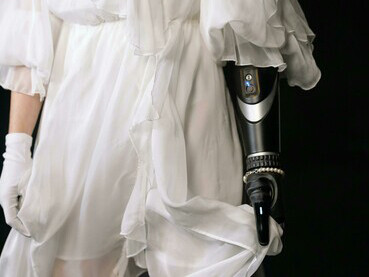 A confident woman in a white dress shirt and gold necklace, seamlessly blending human elegance with advanced robotic technology