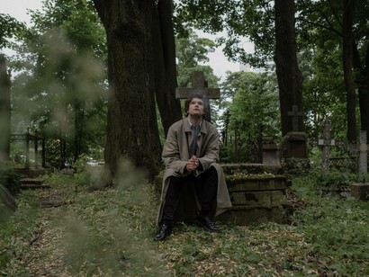 A man looking at the sky as he grieves over his loss with a cigarette in hand