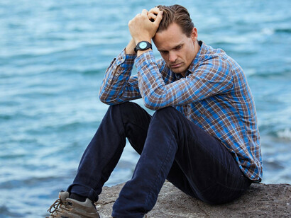 A solitary figure beside the sea, reflecting the emotional exhaustion and longing that weighs everyone down