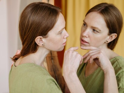 A mulher observa seu reflexo no espelho, criando uma composição em que presença e imagem se encontram. No artigo, essa relação serve de metáfora para a pergunta sobre quanto da realidade percebida é determinado pelo olhar de quem a observa