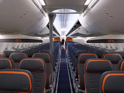 O interior de uma aeronave da Gol revela a configuração padronizada da cabine, com fileiras de assentos distribuídas ao longo do corredor central. A padronização e a busca por eficiência operacional foram elementos importantes do modelo de baixo custo que ajudou a companhia a transformar o mercado aéreo brasileiro