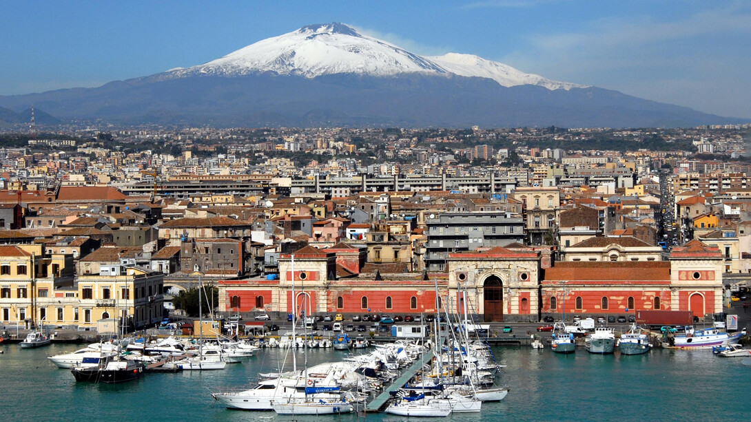 Catania, a city black for the lava stone, white for the limestone of architectural decorations, and blue for its serene skies and the Ionian sea