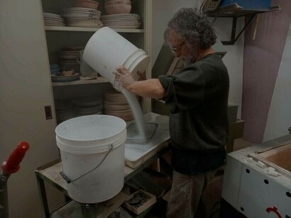 Joan Crous che versa dei materiali in un contenitore di vetro