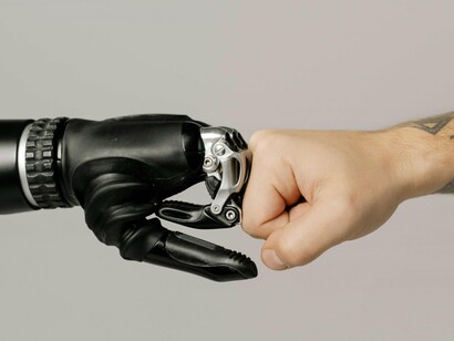 Mão humana interage com mão robótica. Muitos cientistas previram ao longo do tempo quando a singularidade tecnológica iria aparecer. E alguns emitiram avisos terríveis sobre a adoção muito rápida da IA e para onde a IA está indo.
Um mundo diferente não é necessariamente ruim. Pode ser bom