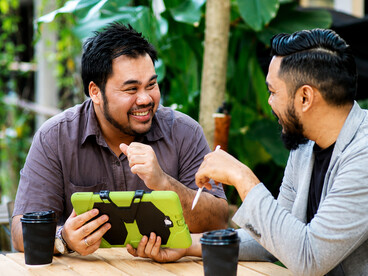 Two friends enjoy a coffee while talking about their concerns in a cozy café surrounded by greenery