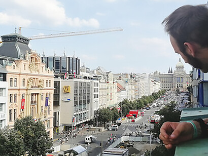Anatol Svahilec overlooking Wenceslas square, his main Prague hood, and watching people from his balcony with the National Museum in the background, photo by Martina Kroa
