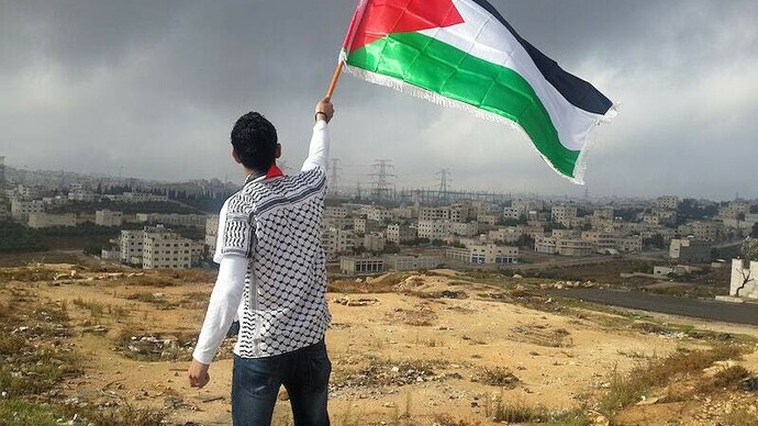 Palestino hasteia sua bandeira. Israel lançou uma operação terrestre em sua fronteira norte com o Líbano visando o grupo militante Hezbollah, apoiado pelo Irã, abrindo uma nova e perigosa fase em quase um ano de guerra. Em alguns campos de batalha, a pacificação é inexistente ou não leva a lugar nenhum