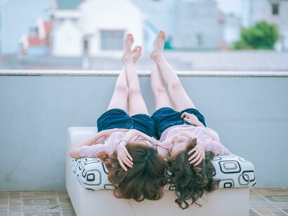 Two friends laying together on a seat 
