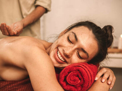 Alternative medicine: A therapist gives an Ayurvedic massage to a cheerful, laughing woman