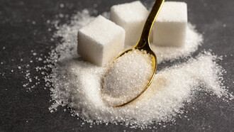 Sugar cubes stacked on a table represent the growing debate over sugar consumption and taxation