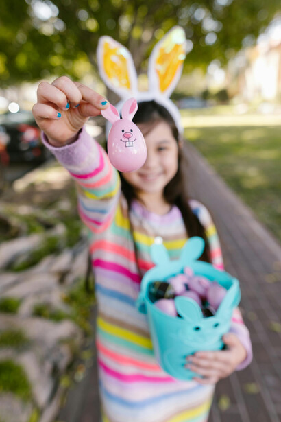 Girl on an Easter egg hunt walking along the street
