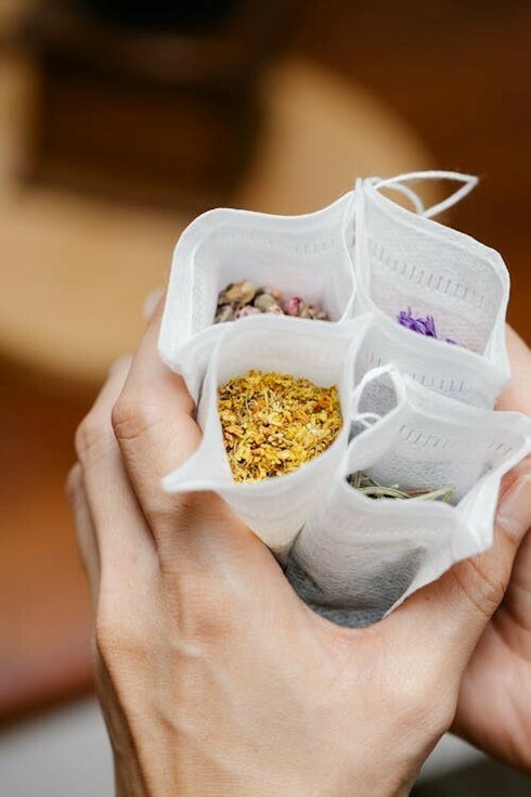 A person carefully packing Ayurvedic herbs into bags, symbolizing the integration of Ayurveda, genomics, and personalized medicine for individualized wellness