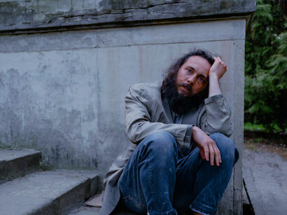 On the streets, a homeless man highlights the stark contrast between global economic capability and individual suffering, underscoring how our resources could eliminate poverty if properly allocated