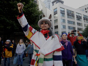 Art Cedar, of the Aluet and Blackfeet tribes, raises a fist at an Indigenous Peoples Day event in Seattle