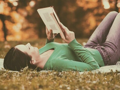 Una chica leyendo en un paisaje otoñal