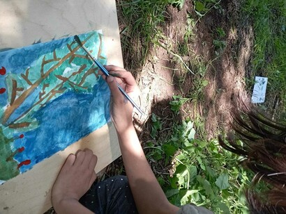 I disegni di un bambino dipinto all'aperto su un prato, Asti, Italia