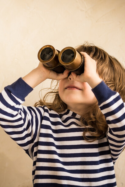 Niña mirando con unos prismáticos