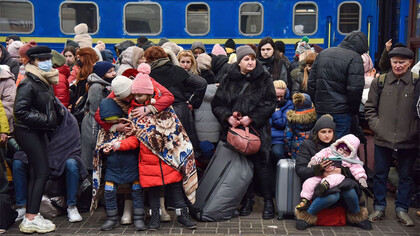Refugiados ucranianos esperan un tren a Polonia en la plataforma de la estación de tren de Lviv