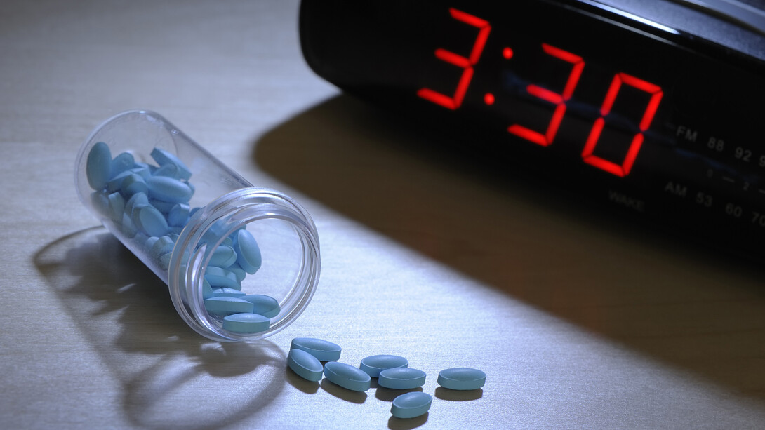 Pastillas para dormir junto a un reloj despertador