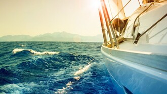 Un barco velero navegando frente a la costa