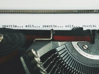 Machine à écrire avec papier indiquant réécrire, éditer, réécrire, éditer
