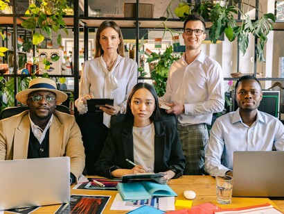 A diverse team of professionals collaborating in a modern office, representing the economic strength created by global talent