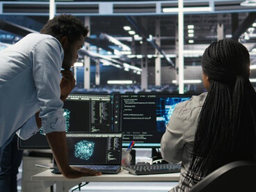 In a decision-making room, analysts observe global data on multiple screens, supporting strategic monitoring by experienced professionals