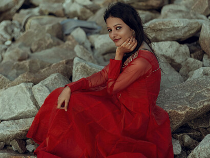 A woman in red, sitting on rocks