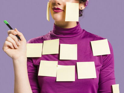 Donna con post-it attaccati al corpo: "Ecco perciò scatenarsi le folte schiere di esperti che ci spiegano -di nuovo a pagamento (e ancora ad alto prezzo!)- come moltiplicare non pani e pesci ma i nostri obiettivi"