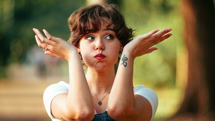A playful woman outdoors striking a whimsical pose