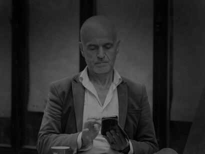 A baby boomer checking out the possible candidates for succession on his phone hoping he finds the right staffer