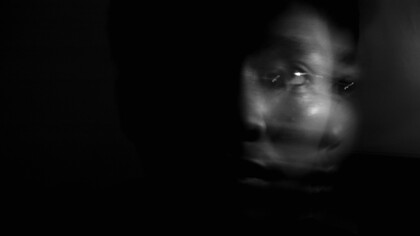 Rosto desfocado irreconhecível na escuridão