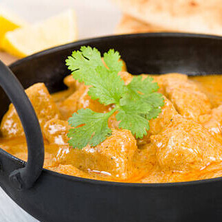 Korma is a traditional dish prepared by slowly cooking meat or vegetables with yogurt, stock, and aromatic spices, resulting in a creamy, flavorful gravy