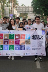 A group of people in Jakarta, Indonesia, hold a white banner promoting the Sustainable Development Goals