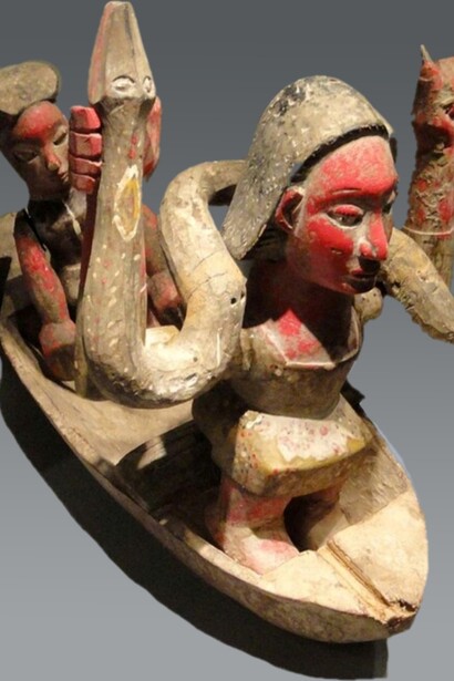Figura di Mammy Wata su una barca, Nigeria. Mostra della collezione africana dello Staatliches Museum für Völkerkunde München,  Monaco, Germania. Mami Wata è spesso rappresentata come una divinità o spirito dell'acqua, venerata per il suo potere di proteggere i mari e i fiumi, garantire la fertilità e la prosperità, ma anche portare sfortuna o malattie se non rispettata
.