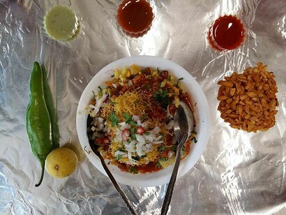 Bhel puri, a mix of puffed rice along with sev and ganthiyas mixed with potatoes onions and dashed up mix of spicy and sweet chutneys often served in India 