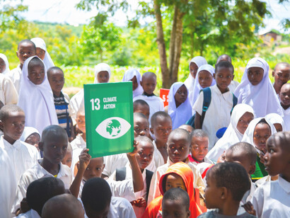 Children actively engaging in outdoor climate advocacy within a rural sustainable development project