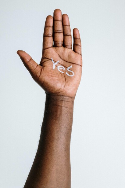 Raised hand with a 'yes' sign