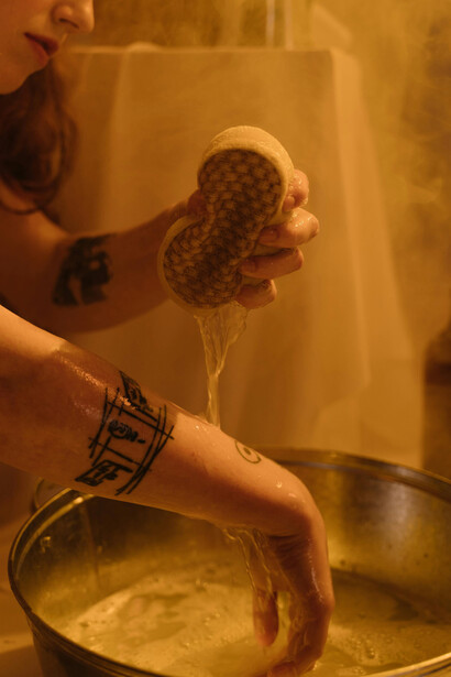 A woman washes her hands in a bathroom, focusing on cleanlines