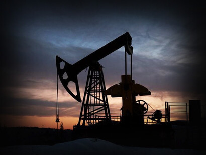Silueta de un torre extractiva de combustibles fósiles durante el atardecer