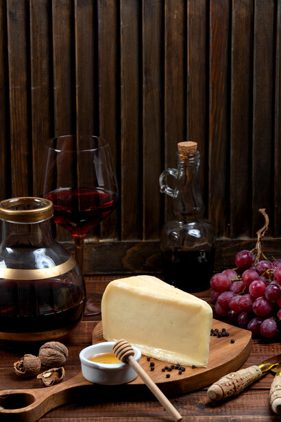 A cheese platter with grapes and wine for perfect pairing